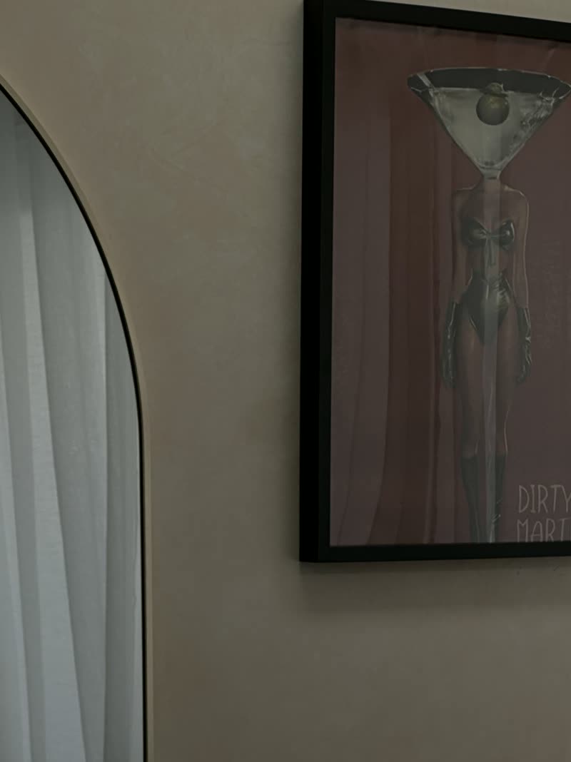 A dirty martini print above the arched mirror.